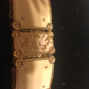 White enamel and gold tone stretch bracelet with floral design